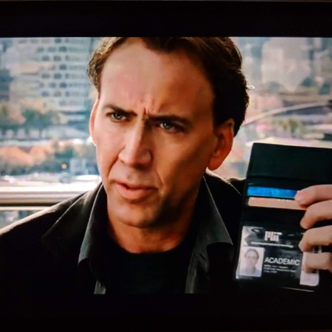 Still of Nicolas Cage flashing an "Academic" badge from the movie KNOWING 