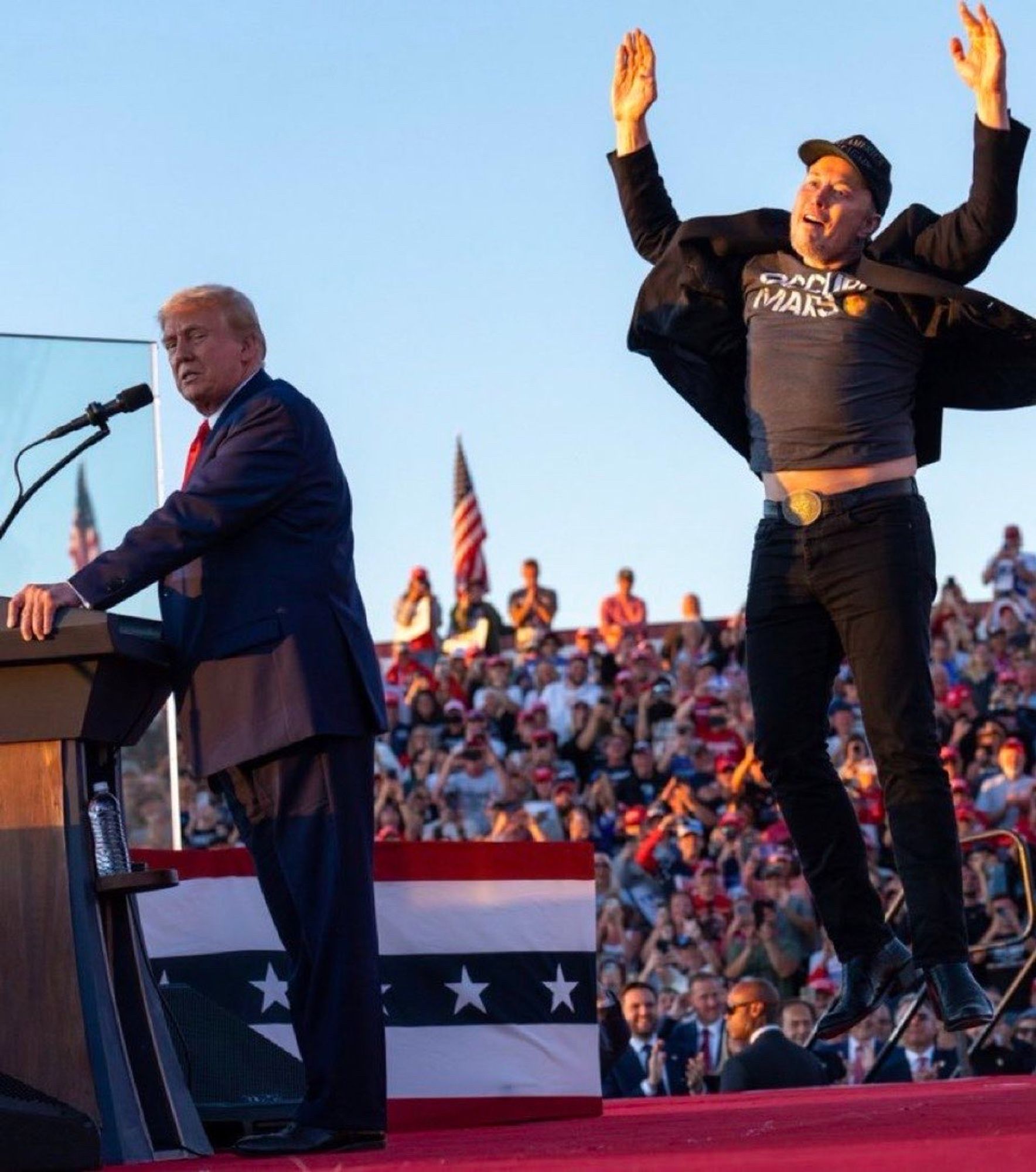 Trump grumpily clutching the podium while Elon leaps happily behind