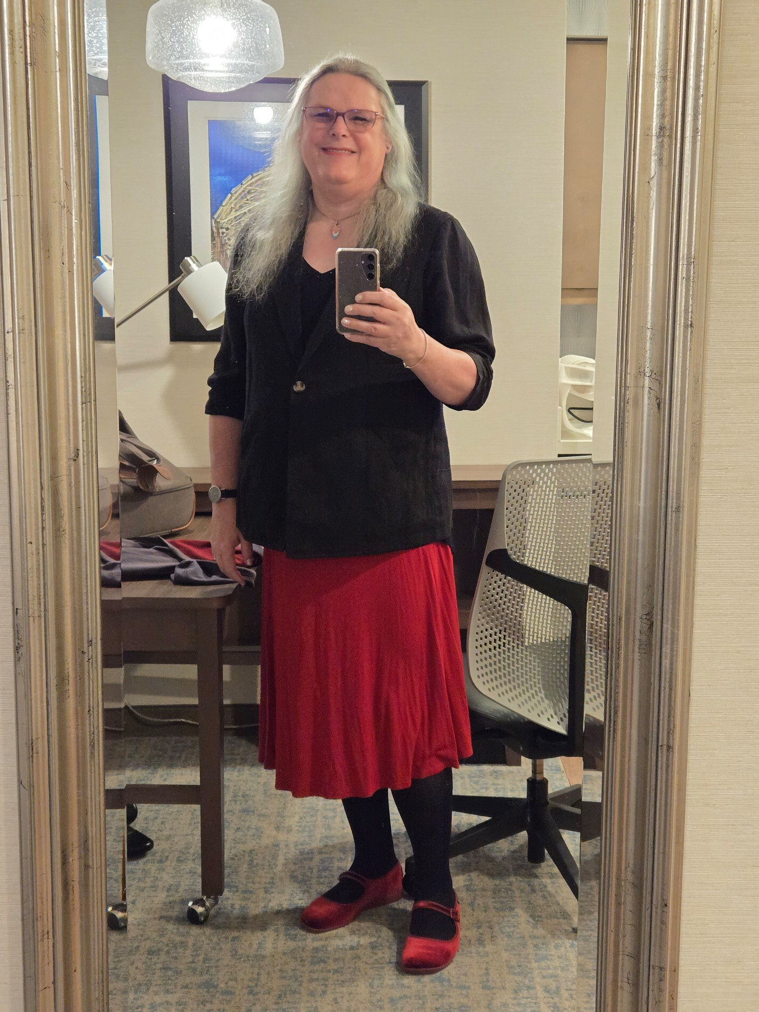 Full-length mirror pic hair down, black jacket and top, red skirt, black tights, red Mary Janes.