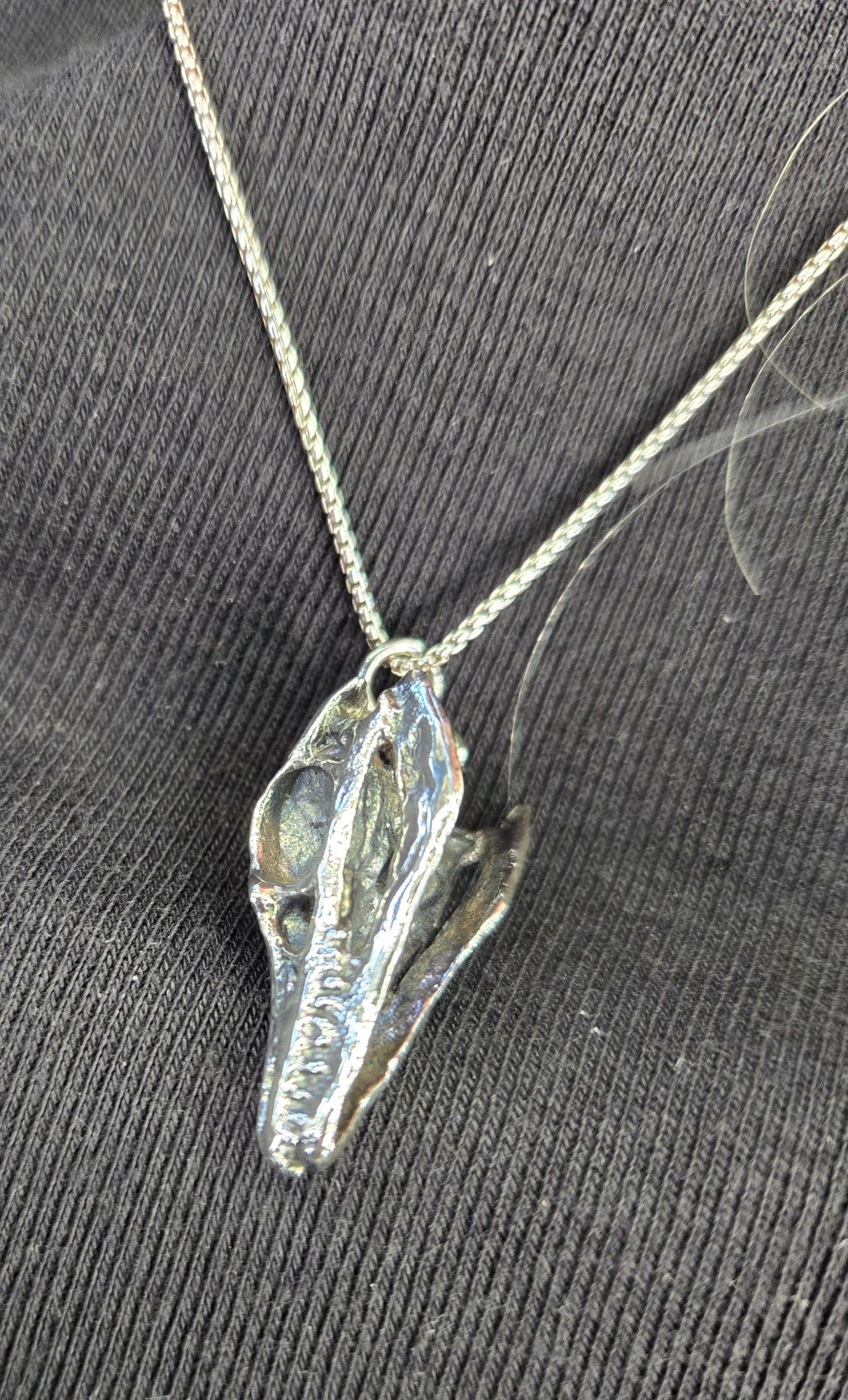 Silver archaeopteryx skull necklace.