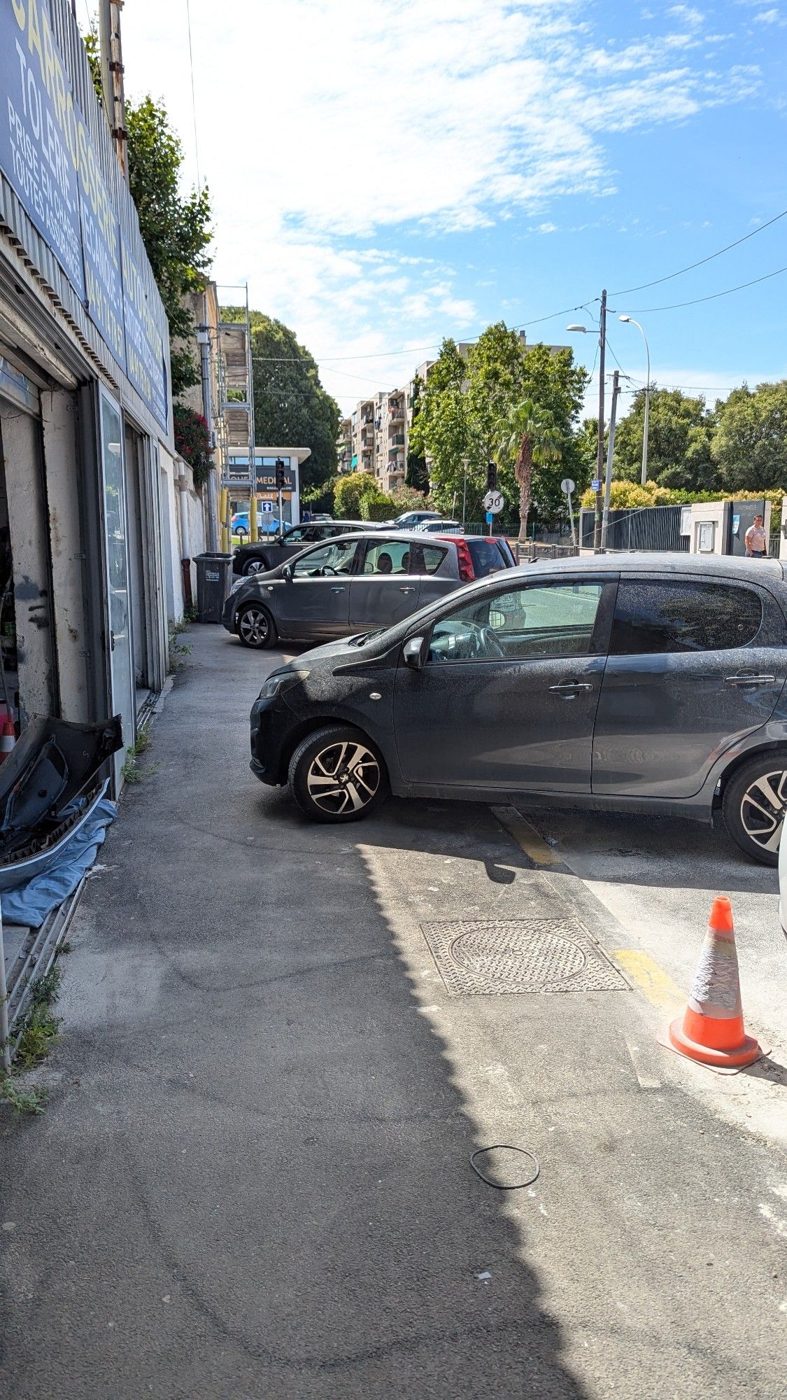 Un trottoir bloqué par plusieurs voitures mal stationnées.