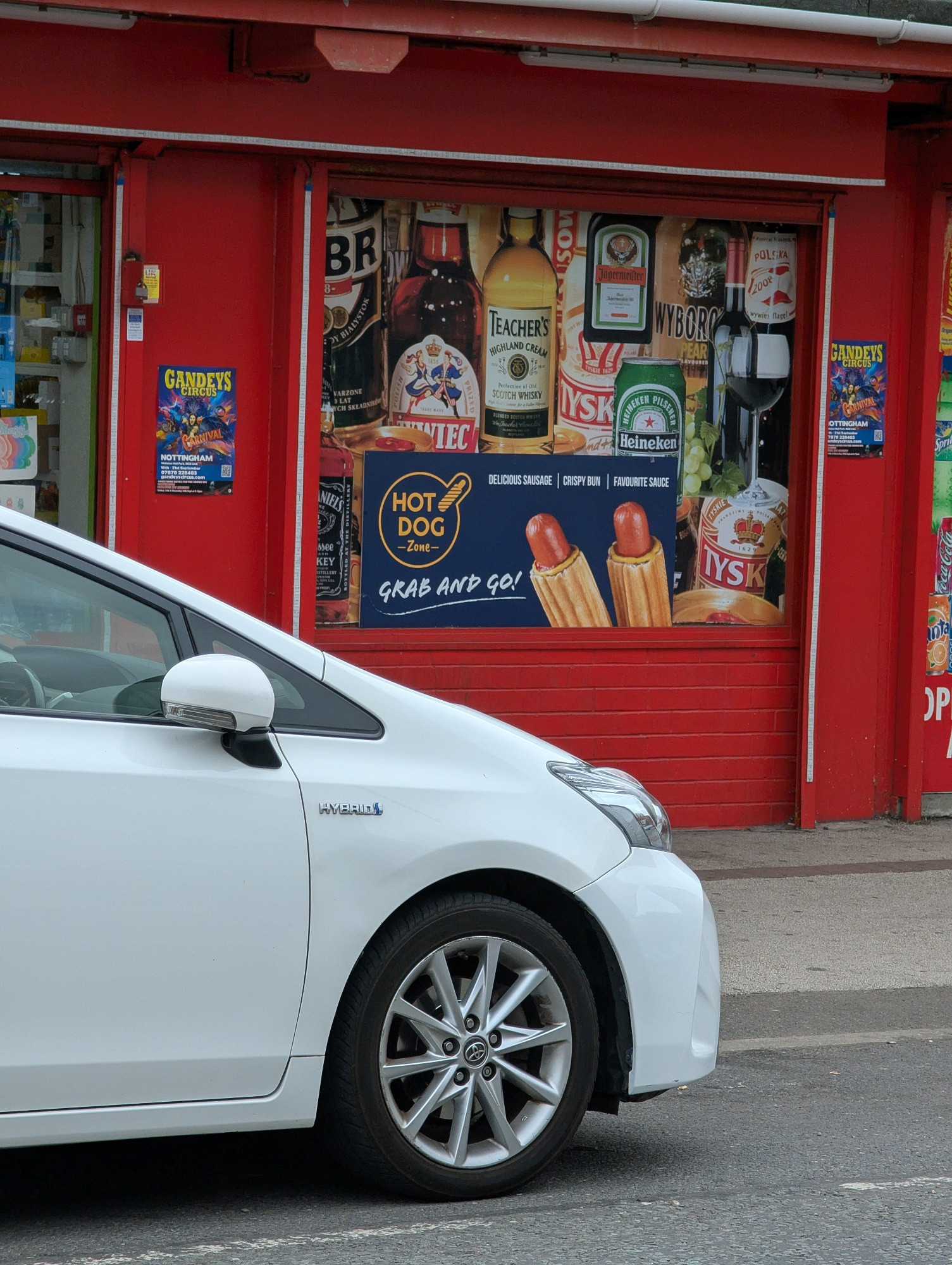 Hot dog advert in the window of a shop. They look like cat penises 