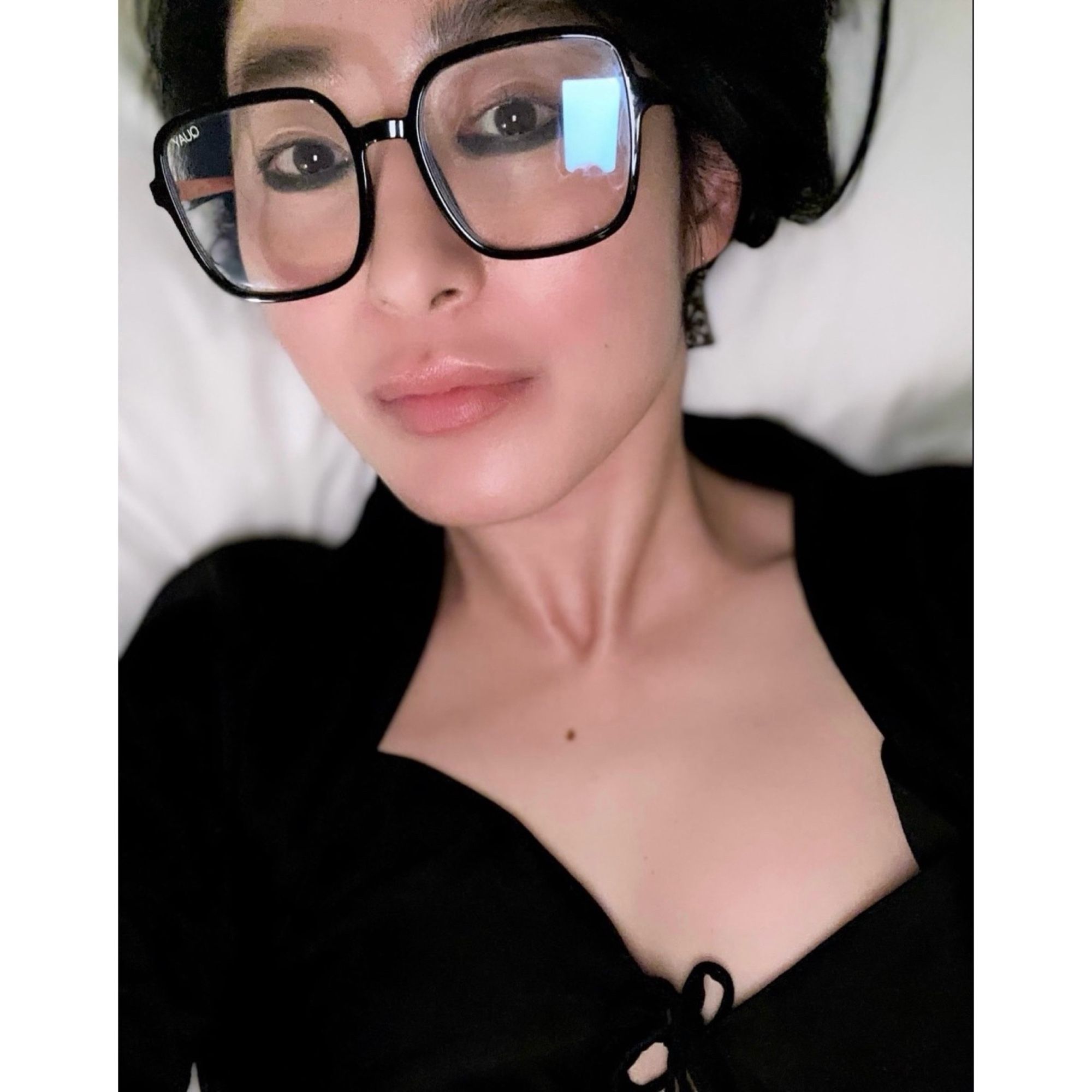 selfie of Korean woman in black dress & black dresses, lying in bed