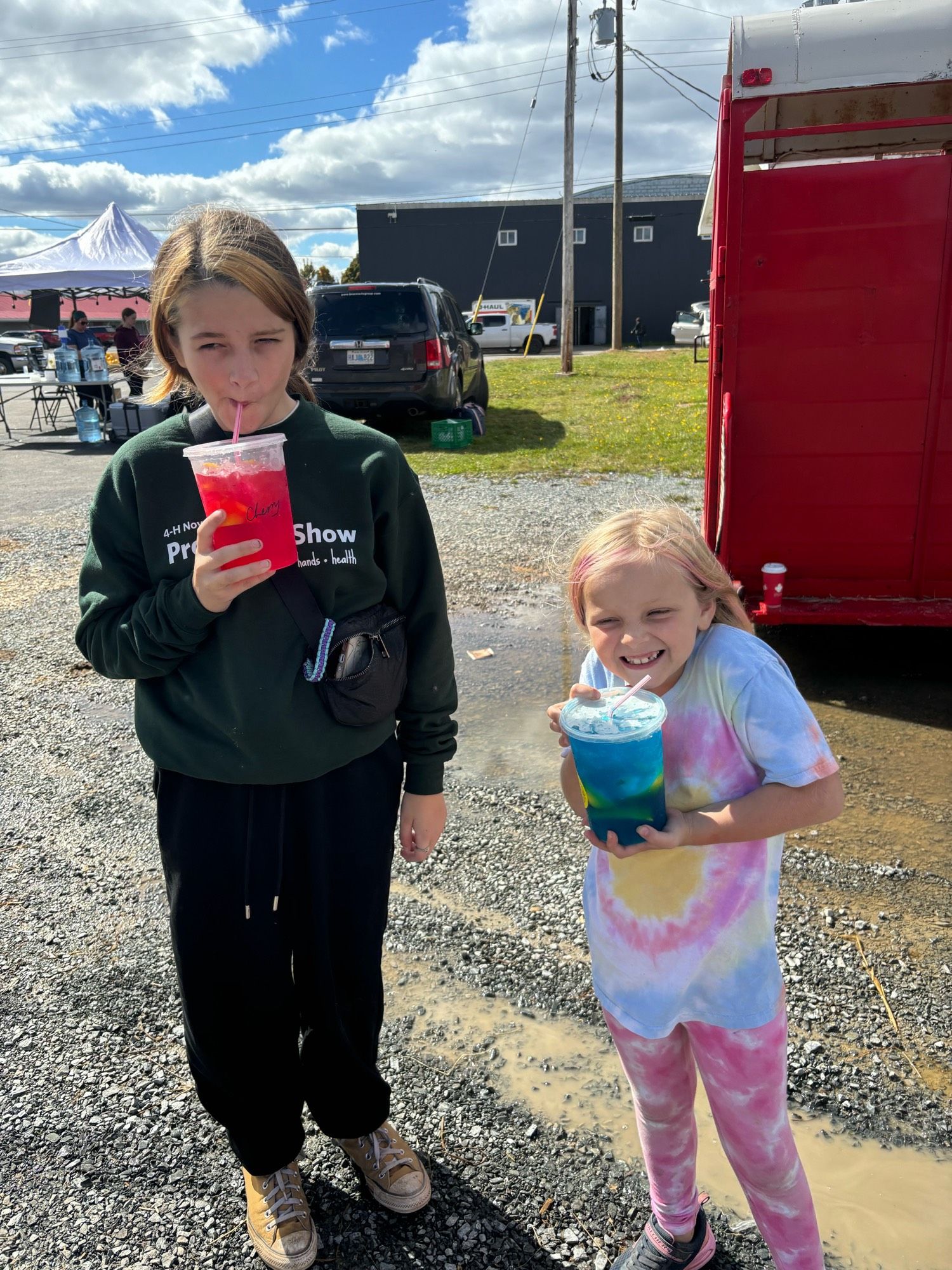 Two girls drinking coloured buckets of lemonade