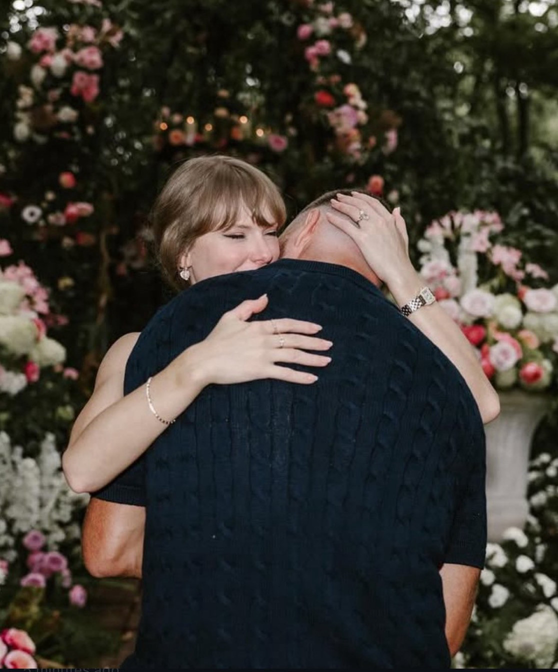 Taylor Swift and Travis Kelce embrace surrounded by flowers during their engagement proposal 