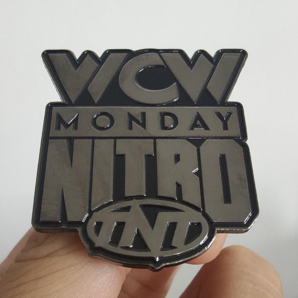 Dark gray enamel pin of the WCW MONDAY NITRO on TNT logo