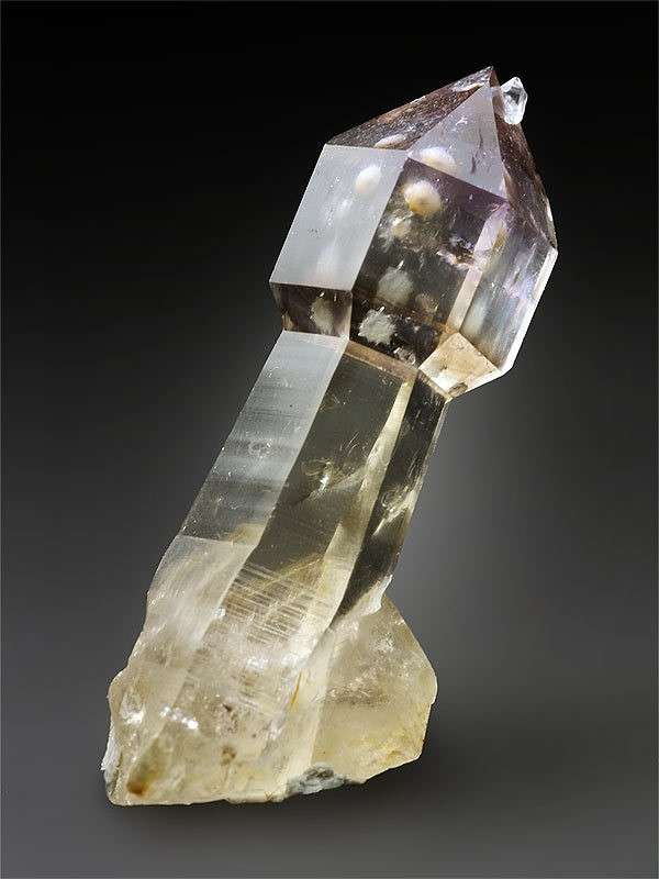 A quartz tower with an expanded tip. The amazing thing about quartz is that it is clear when pure, but any elements around at formation can affect the color, which spans the rainbow, and can create tiny worlds inside the crystals with included growth. There are even specimins with water included, and that water is millions of years old! (This particular piece appears to have calcite or something similar included in the tip