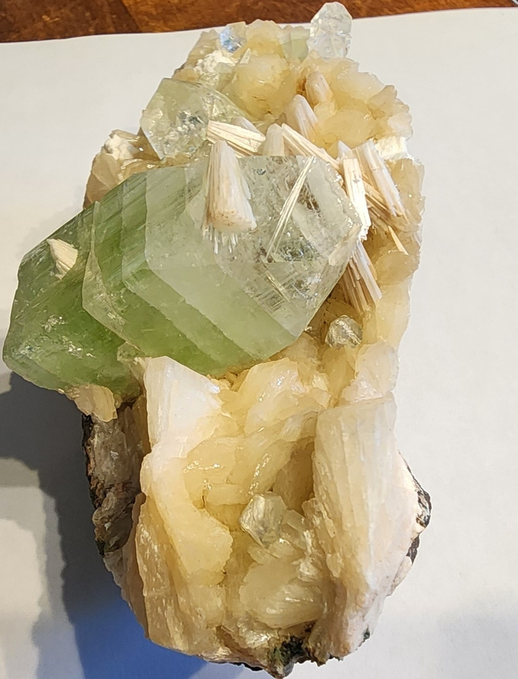 This shot rotated to see the green Crystal from reverse shows stress fractures across the surface throughout the larger Green Piece and the white fibrous crystals of stilibite that are growing out of it