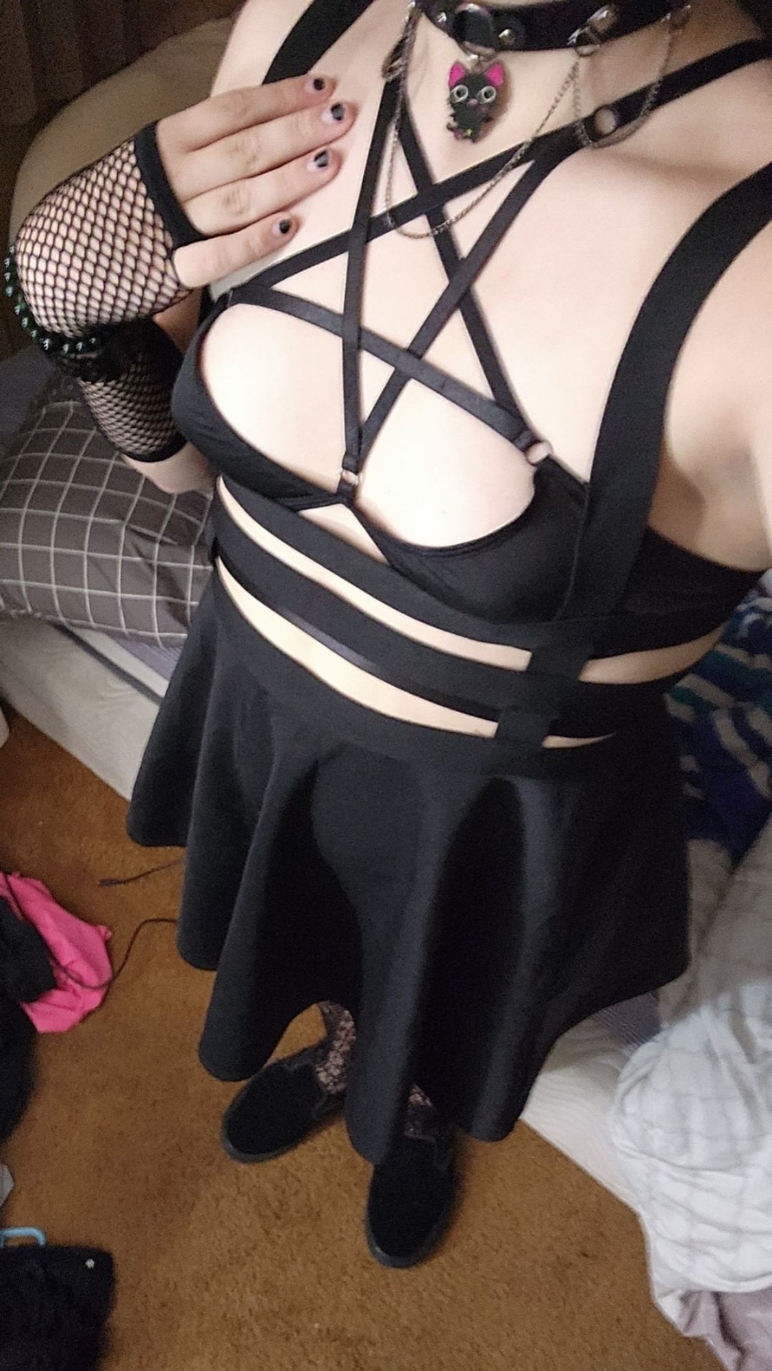 A woman posing in pentagram lingerie and fishnets