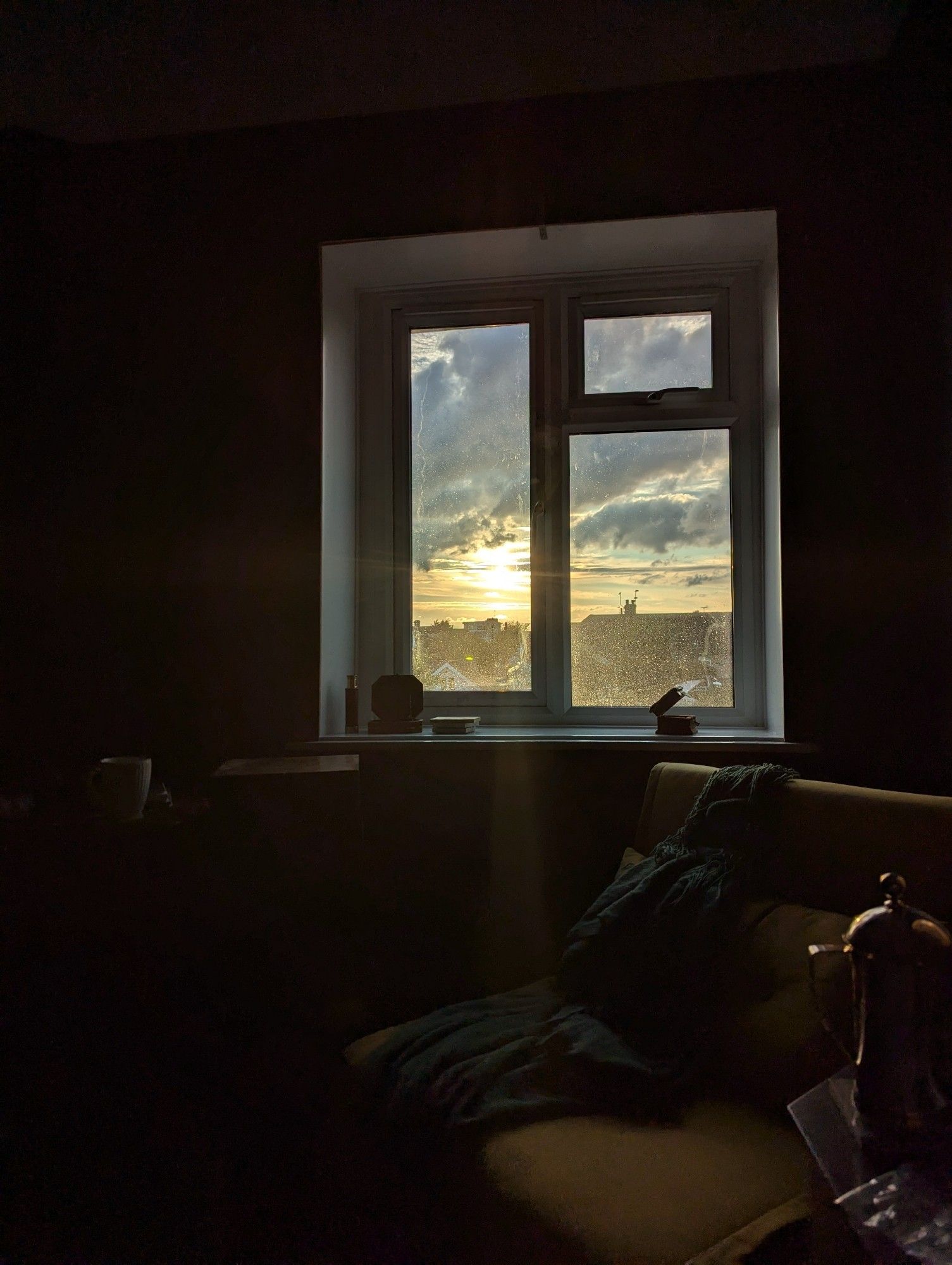 Dramatic looking sunset seen through the window of a darkened room.