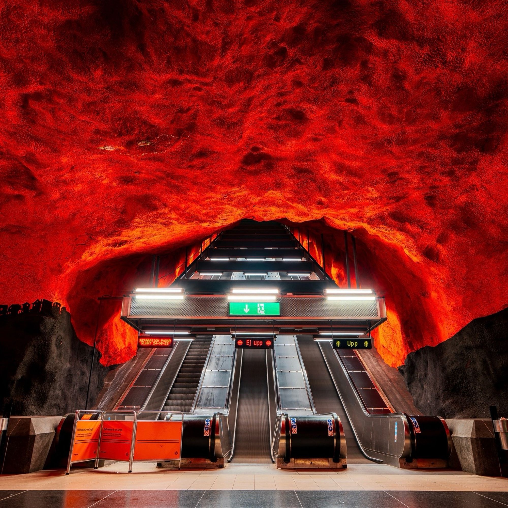 Stockholm metro station interior, with the cave like wall painted in bright red.