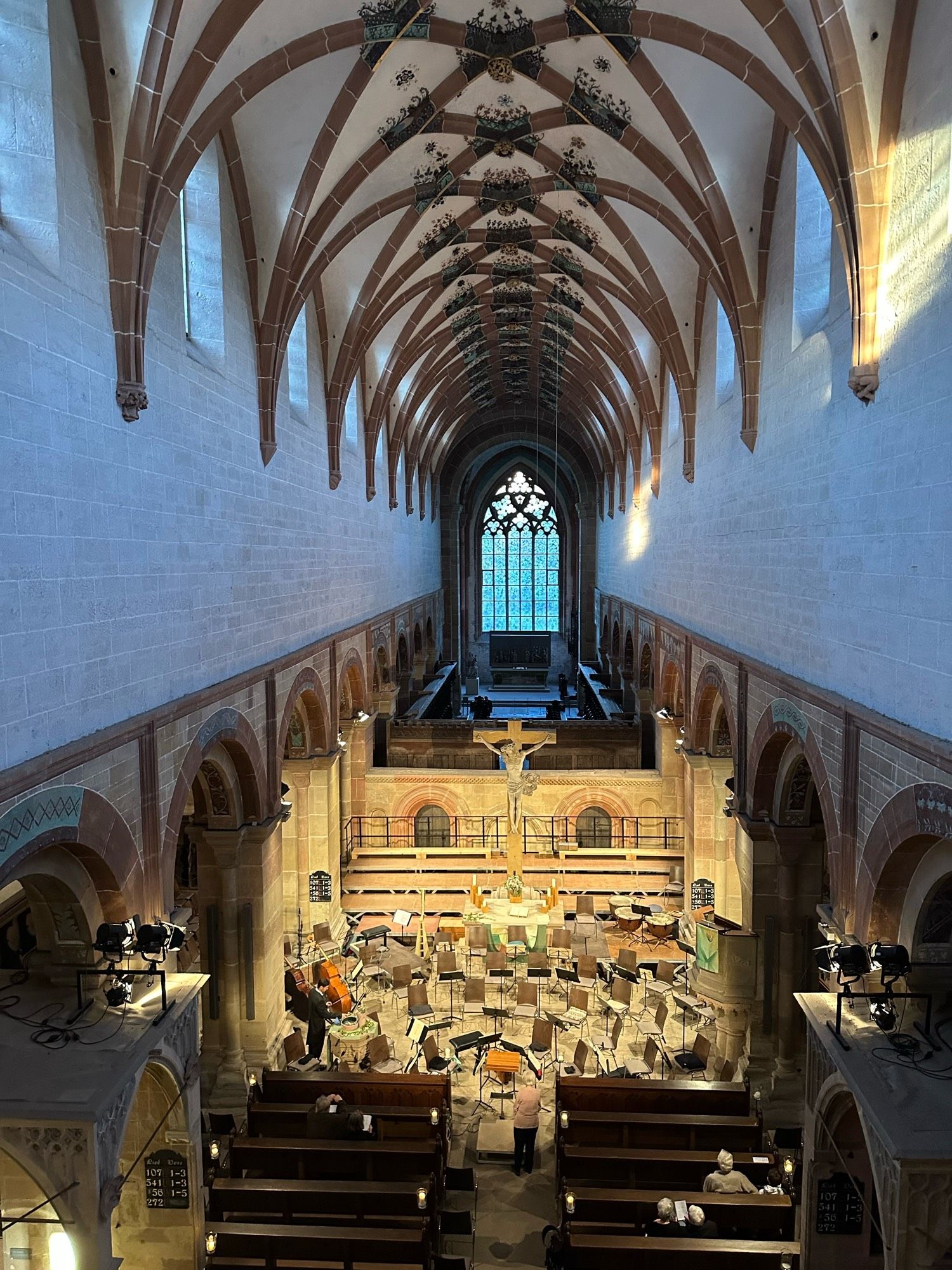 Blick von der Orgelempore in die noch leere Klosterkirche. Im Altarraum stehen Notenständer, Stühle und leere Podeste für das anstehende Konzert