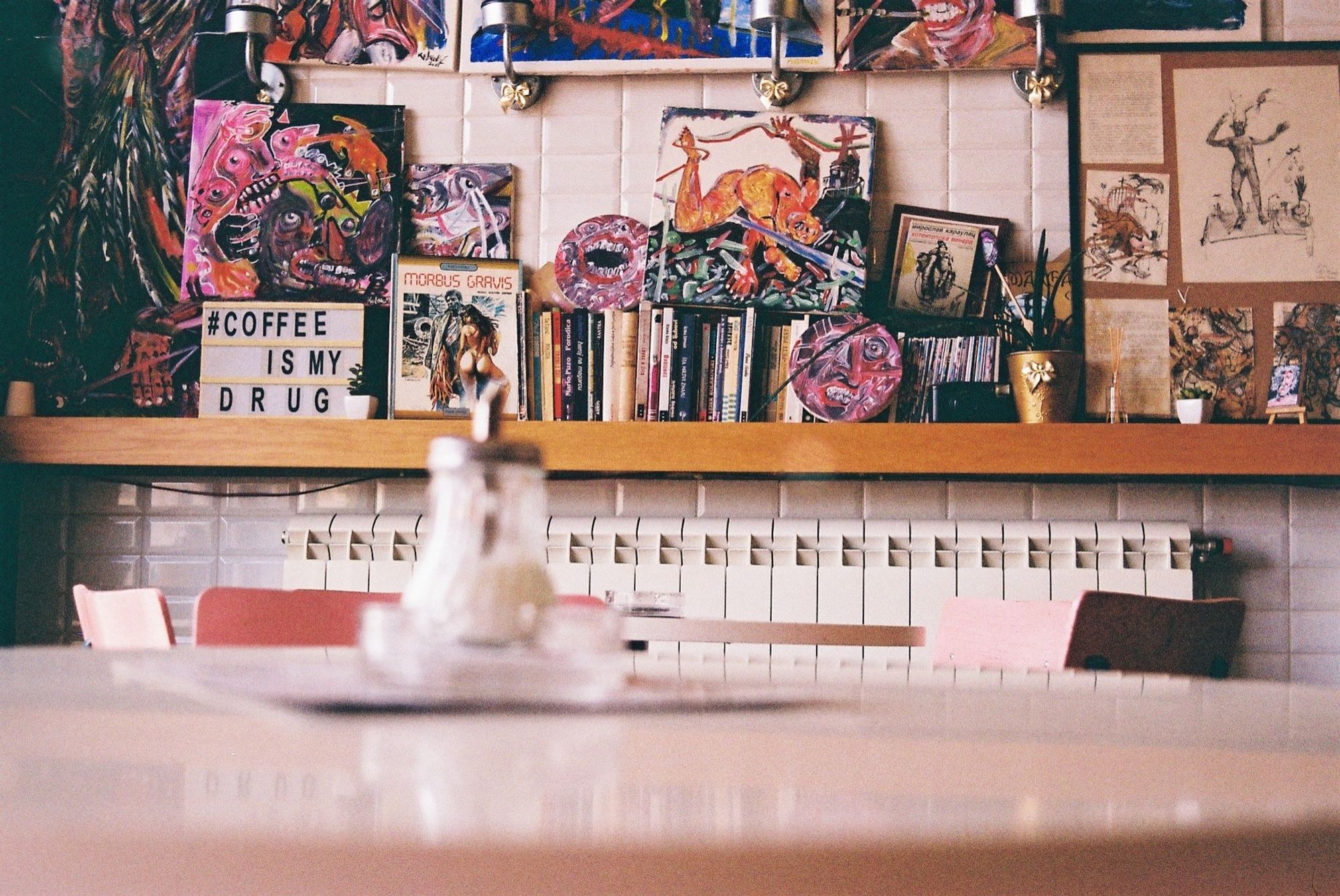 Interior of a coffee place full of abstract figurative art, books, frames. Coffee Corner, Novi Sad, Serbia.