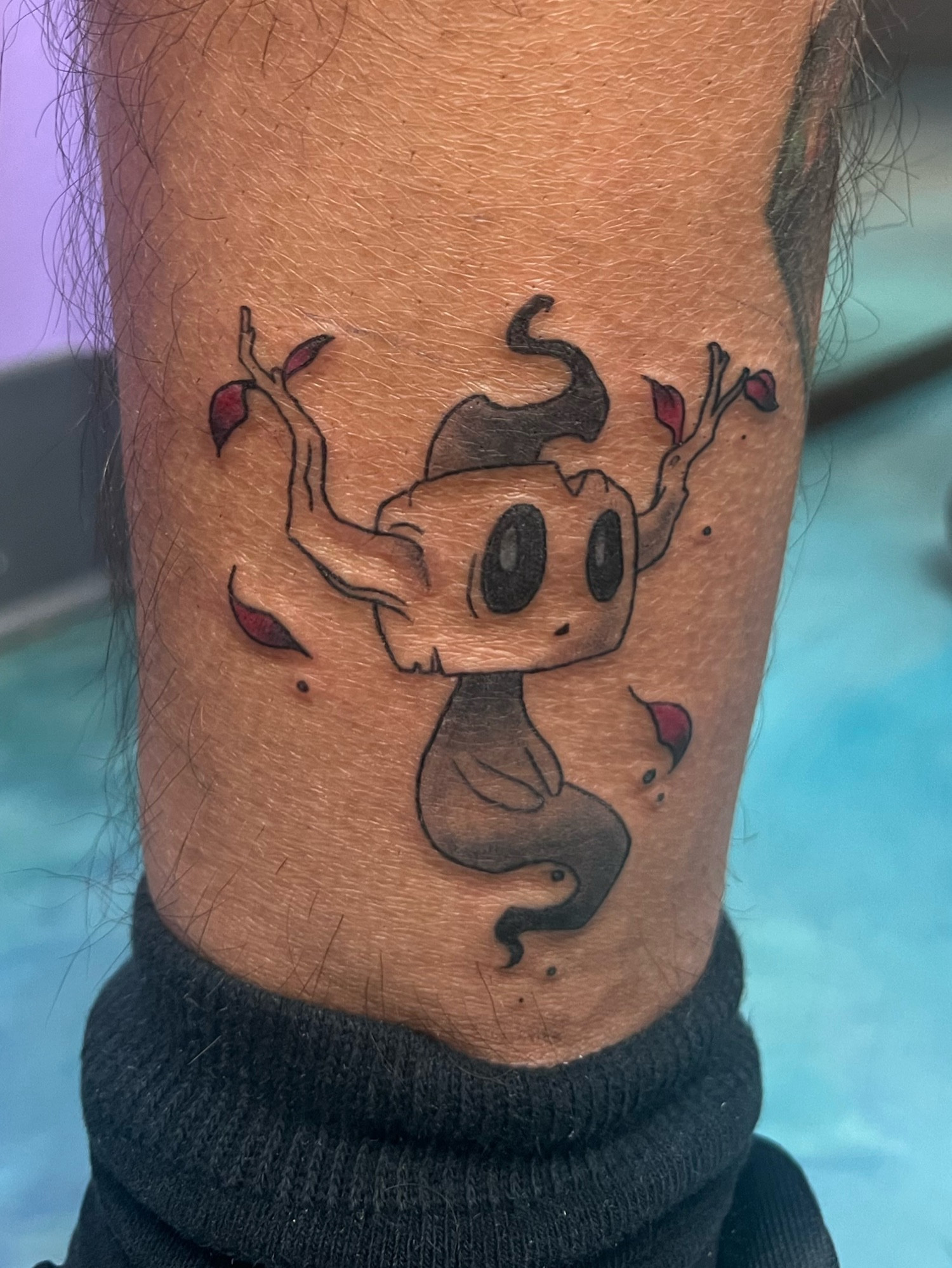 A tattoo on a clients ankle of a shiny phantump! It has extra red leaves floating beside it.