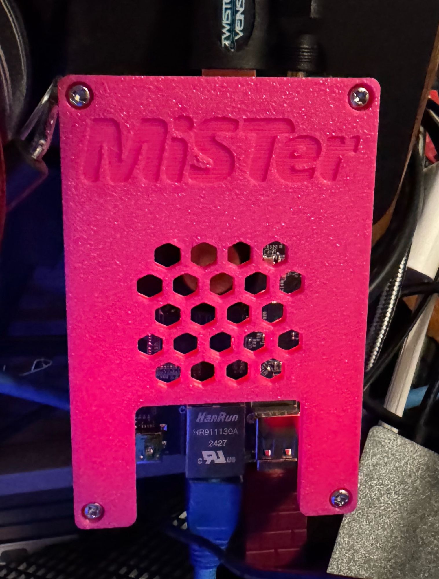 A photo of a QMTech DE10 Nano Cyclone V Development board in a pink case that says MISTer.