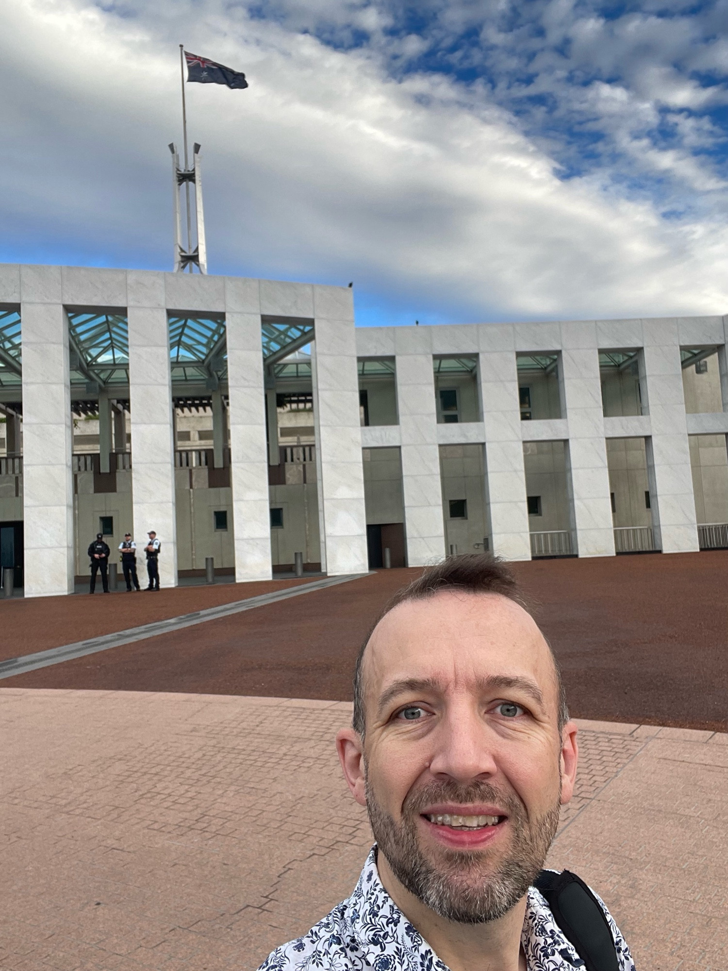 Me, a middle aged white man, in front of Parliament House in Canberra