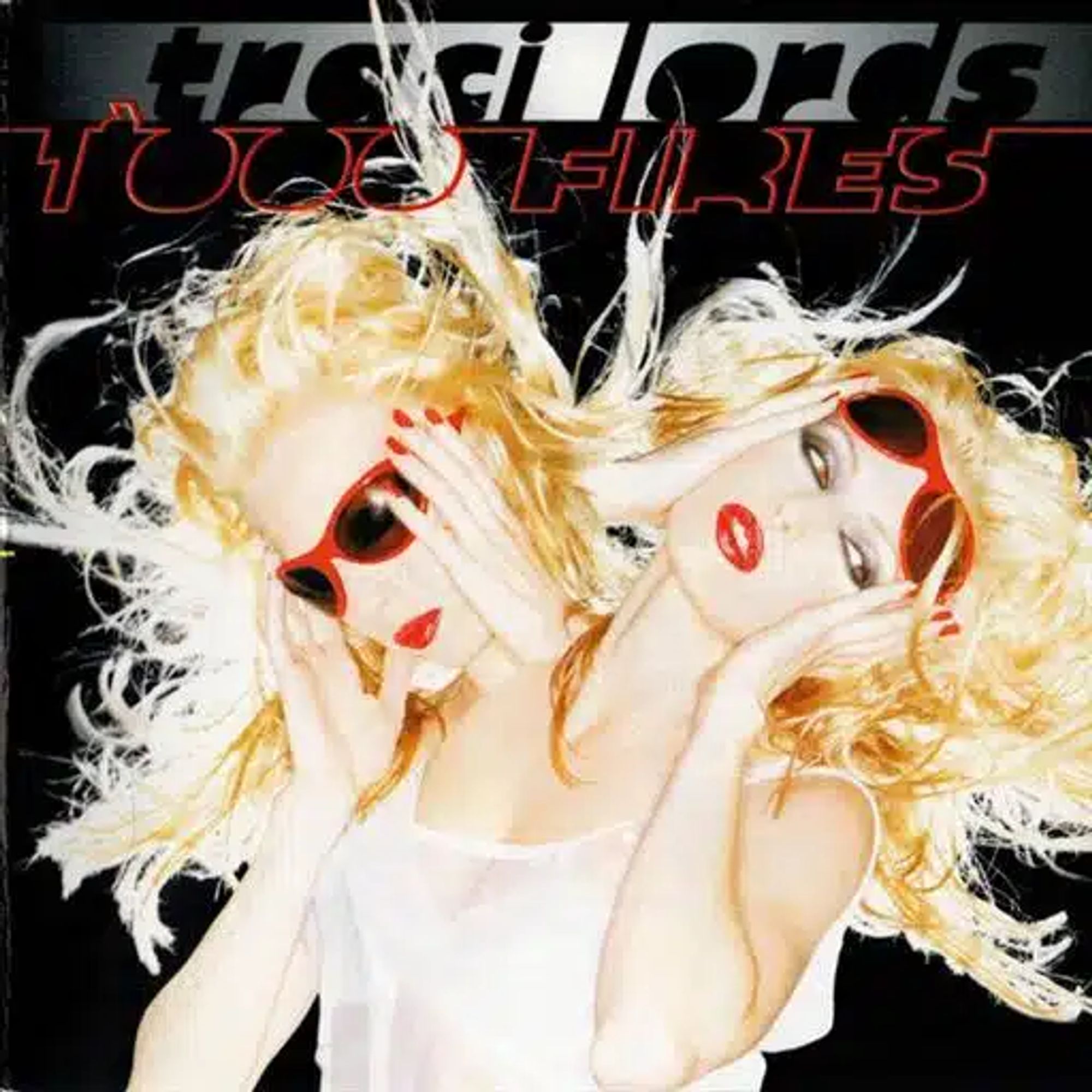 A black album cover with stylistic writing at the top showing the name "Traci Lords" almost in shadow on a silvery background, then the neon outline of "1000 Fires" below. The main imagery is of a blonde woman. She has pale make-up, red lipstick, a pair of shades with red rims on, and she's wearing a light, white, sleeveless top. She's shot from the waist up with very high flash making her almost glow. Two photos with the artist's head in different positions have been manipulated to make it appear as if she has two heads and sets of arms, one with shades on, listening, and one with shades raised, eyes looking to the side.