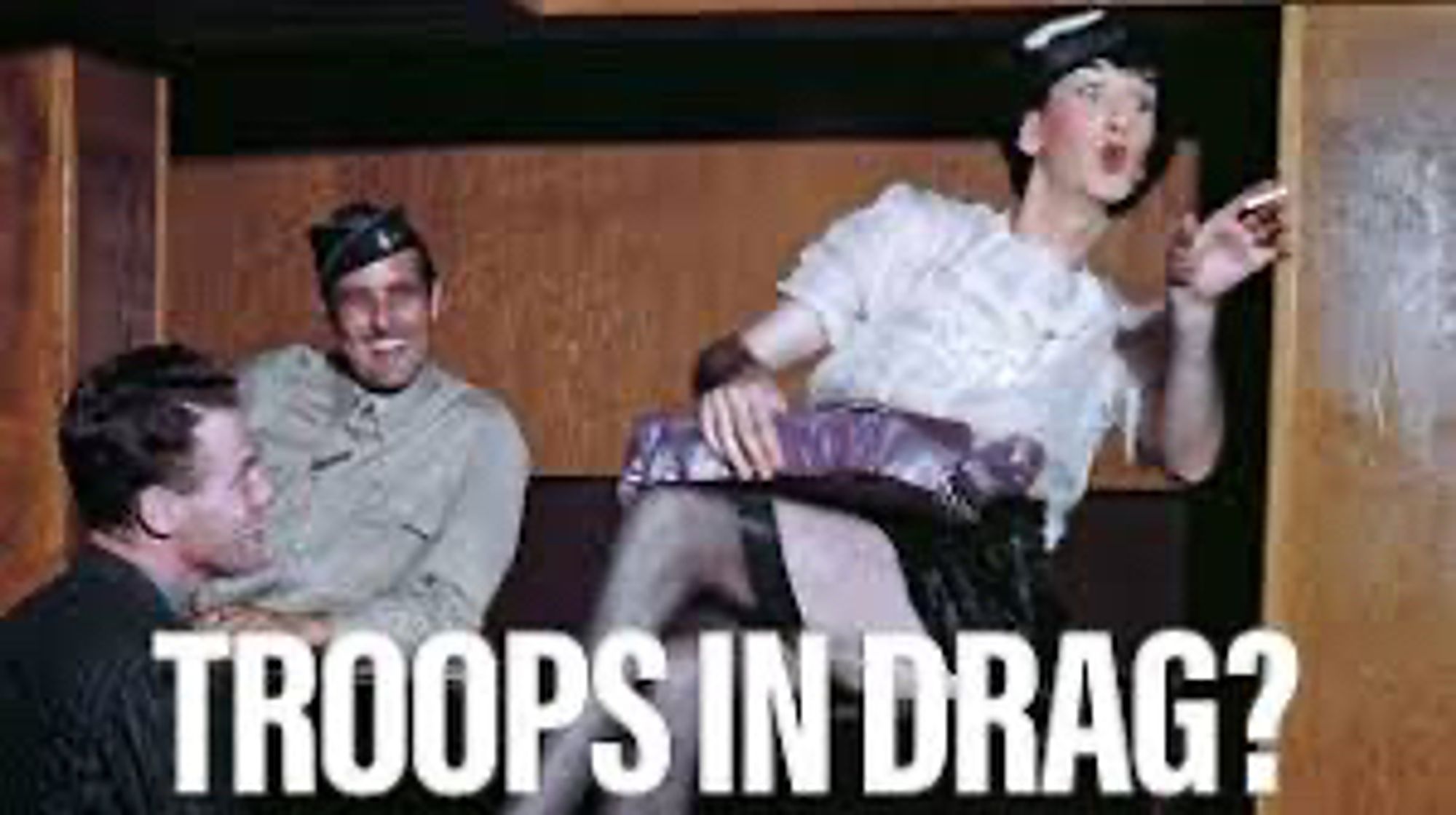 Two US soldiers watch a drag performance during WWII. Text is title of linked article, "Troops in Drag?"