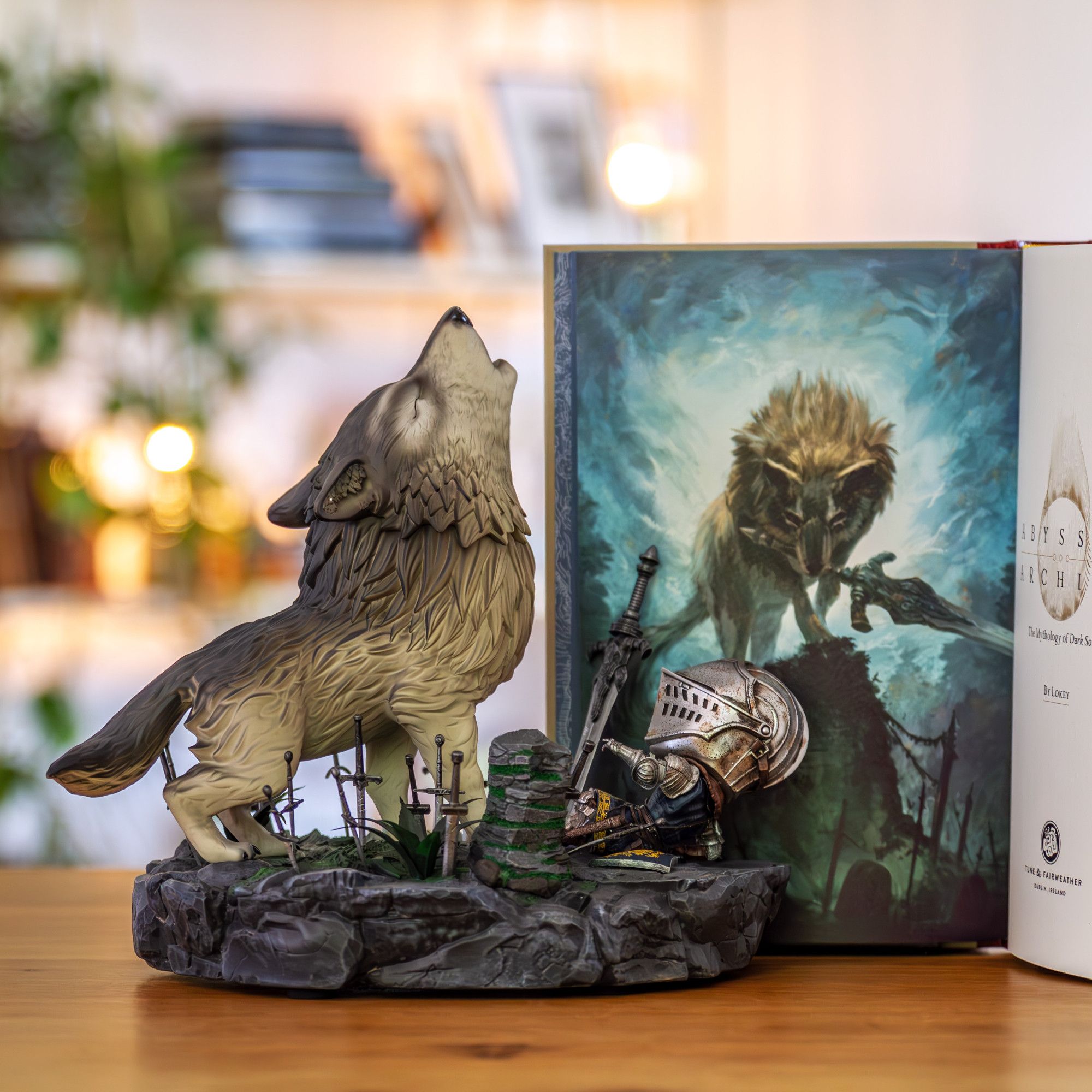 Photo showing the frontis illustration of Abyssal Archive: Sif wielding the Greatsword of Artorias. In front of it a figure of Sif howling before picking up the Greatsword of Artorias and attacking the Chosen Undead.