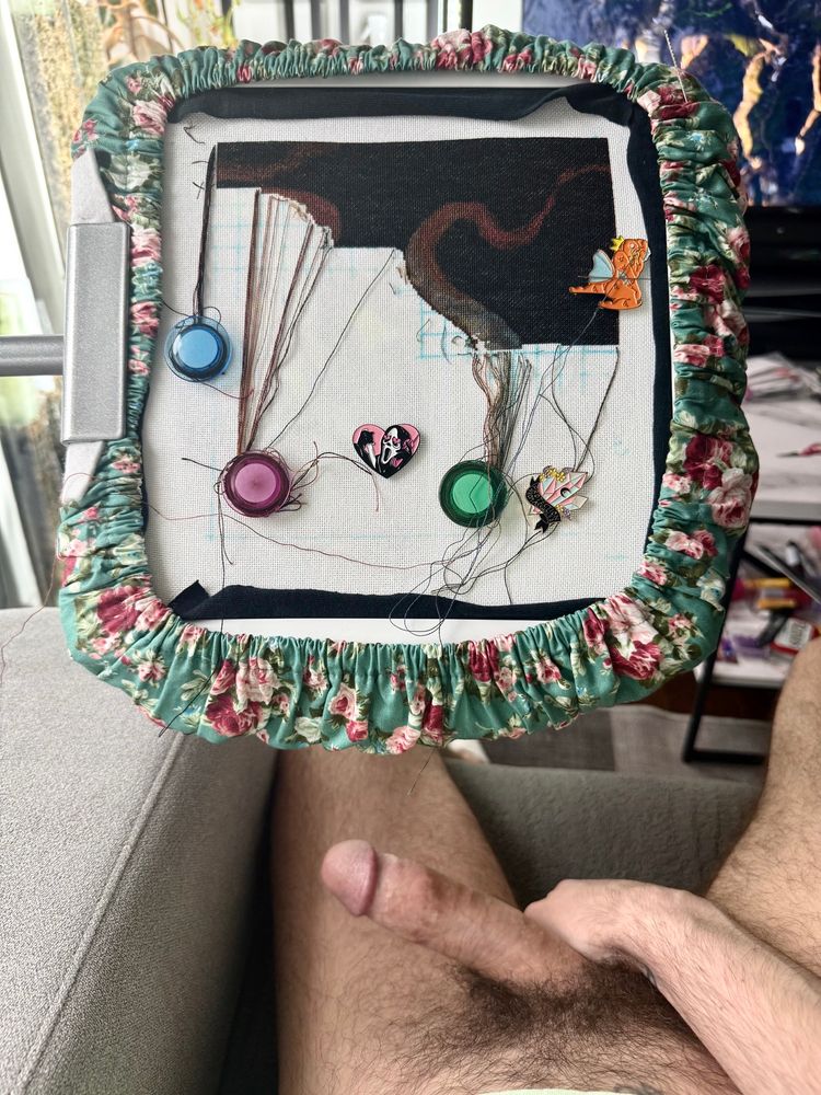 A photo of my naked lap. Penis is erect. My cross stitch project pulled forward showing a tentacle in the making. 