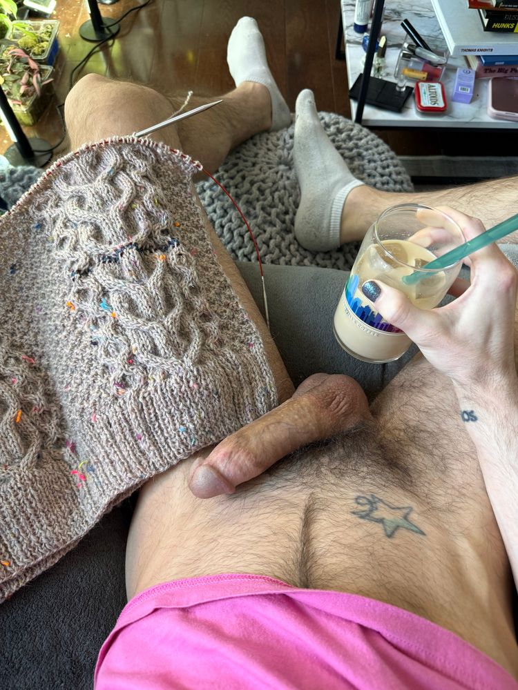 My naked lap with an erection. Tan cabled knitting project on my left thigh and an iced coffee in my right hand. 