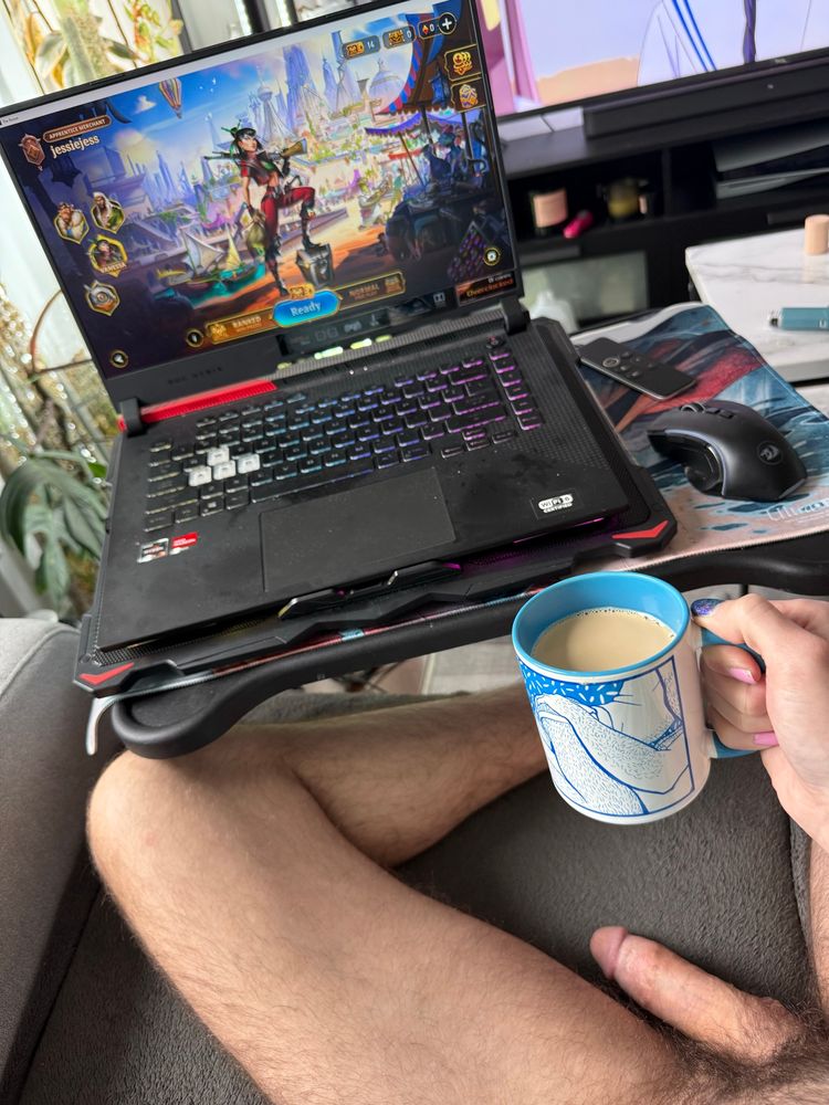 A photo of my naked lap. Dick is in a state of semi erect. Playing The Bazaar on my laptop. Holding a mug of coffee in my right hand. 