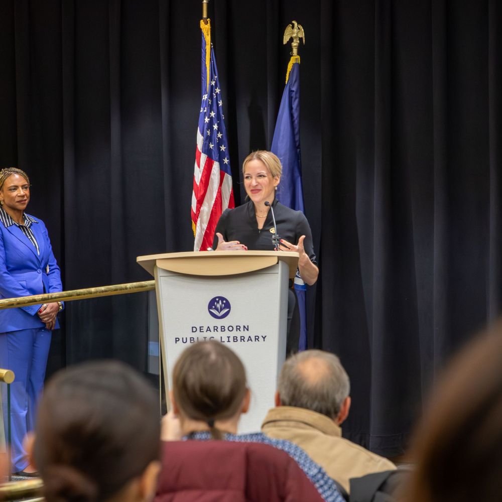 Secretary Benson stands at a podium to share how a simple, “thank you for your service” helped her during an uncertain and fearful time as her husband prepared for a deployment to Afghanistan.