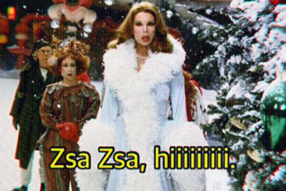 The glamourous Martha May Whovier stands tall in a pastel baby blue and white trim feathered robe. Her hair coiffed and her lips perfectly rouge and plump. The grand dame uses her velvet voice to beckon and bellow her annual festive hello to the one and only Zsa Zsa. And Christmas was saved, not by the Grinch, but by the girlies.