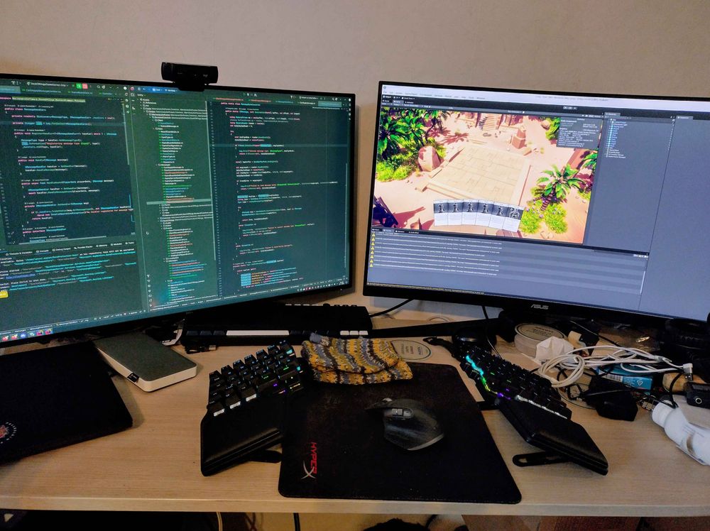 An image of the "spaceship" featuring my desk, the new keyboard and two monitors with the game I'm working on