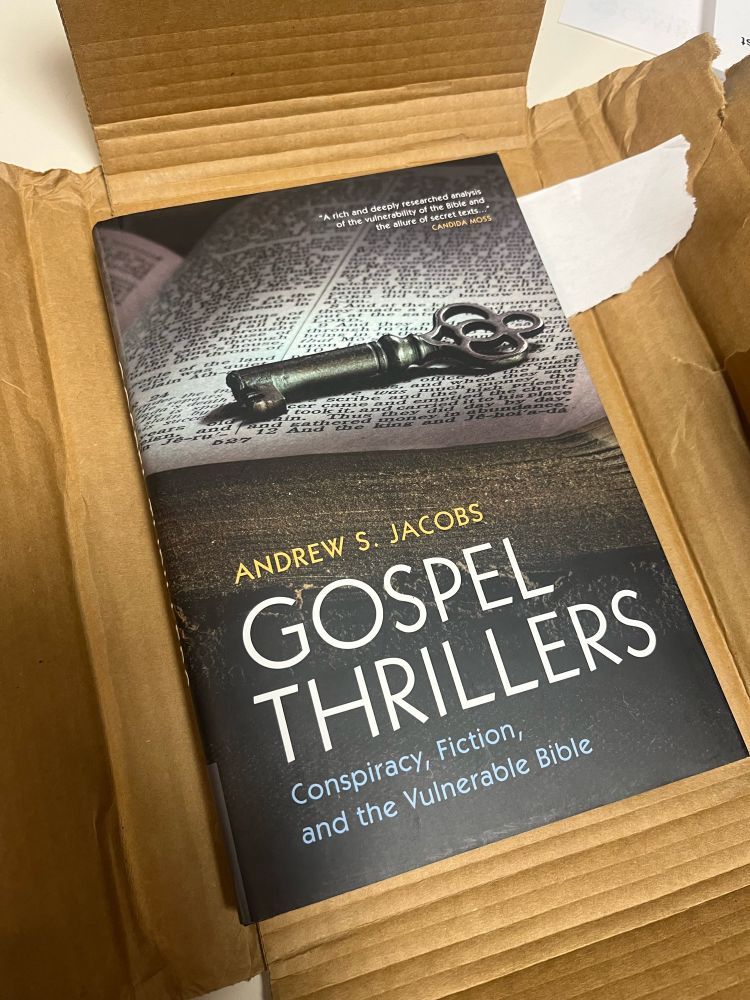 A hardcover edition of Andrew S. Jacobs’ book Gospel Thrillers: Conspiracy, Fiction, and the Vulnerable Bible, laying in a recently-opened cardboard package