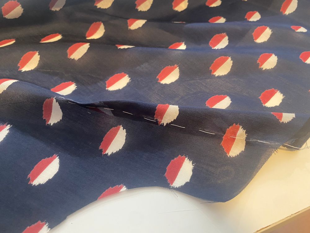 Bust dart tacked on navy silk fabric with white thread to hold the bust dart in place while sewing and provides a stitching line. 