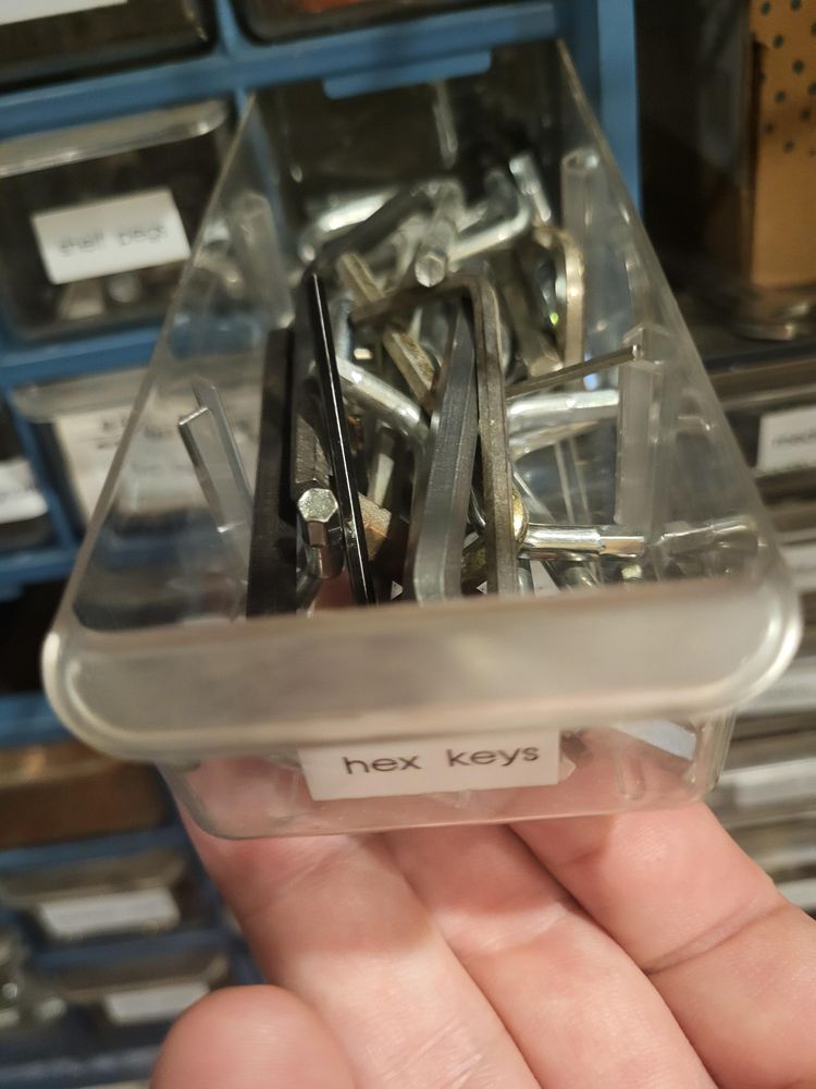 A small plastic drawer (pulled out and supported by my right hand) with a label on the front that reads "hex keys".

It is, in fact, full of hex keys.