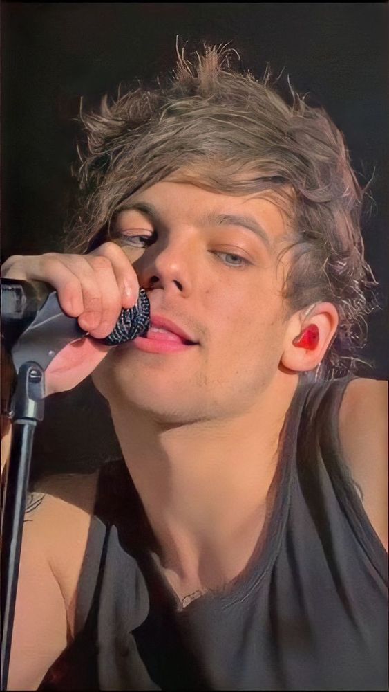 Louis Tomlinson with his tongue between his teeth like a sexy kitten