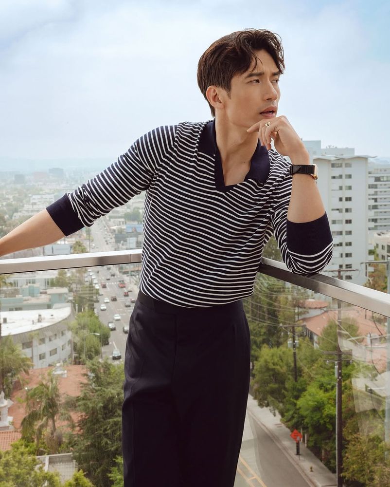 Manny in blue and white striped top and trousers, standing up, smouldering