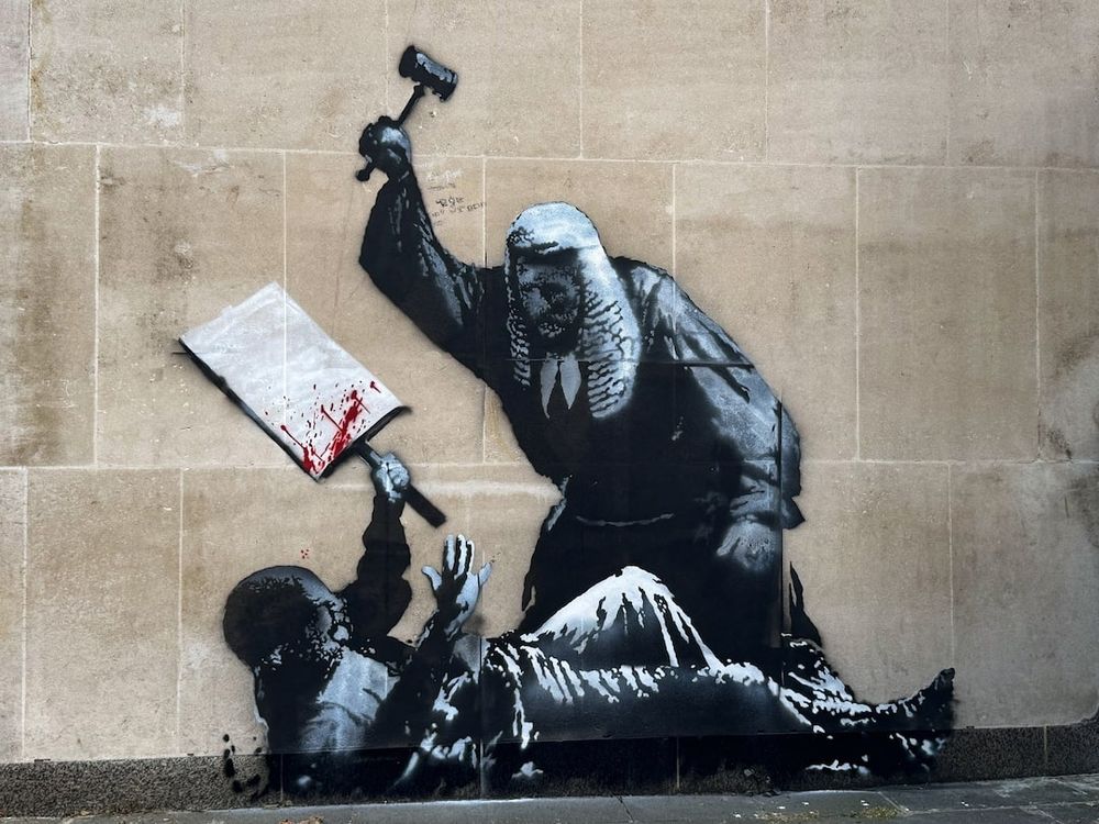 New Banksy art of a judge beaten a protestor with a hammer 