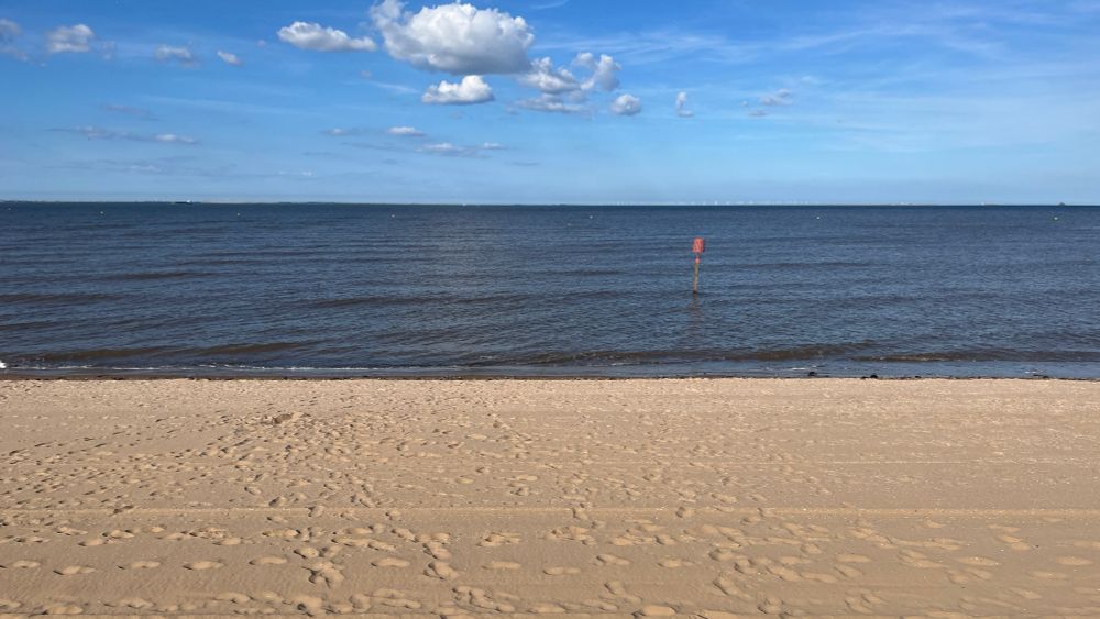 Layers of sky, water, and beach