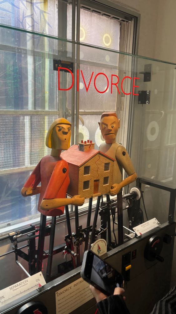 A machine called “Divorce” featuring two mechanical people in tug-o-war with a house. Turning a crank splits the house in half.