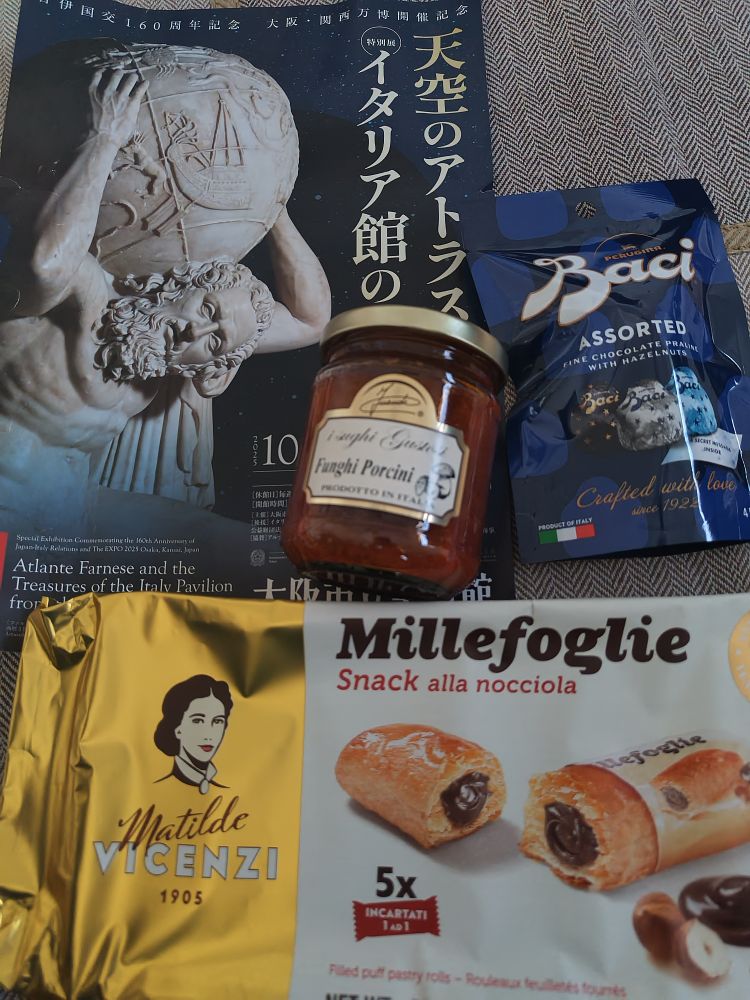 美術館のチラシ、パスタソース、チョコレート菓子の袋、チョコレートがパイ生地で包まれたお菓子。
