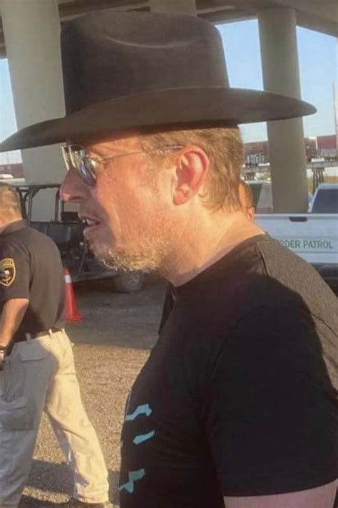 Elon Musk wearing a black cowboy hat backwards 