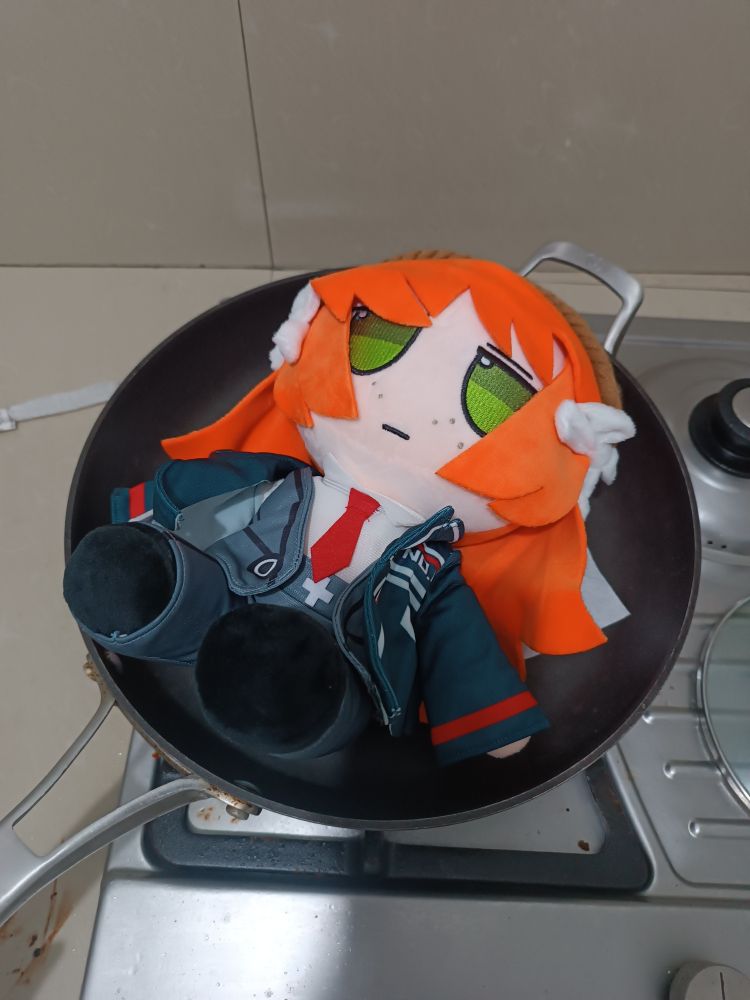An image of a fan made plushie of Ishmael from limbus company laying down on a frying pan over a stove (that is switched off)