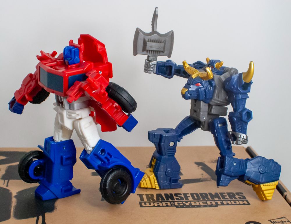 Cyberworld Optimus Prime, being chased by Cyberworld Megatron, with his weapon.