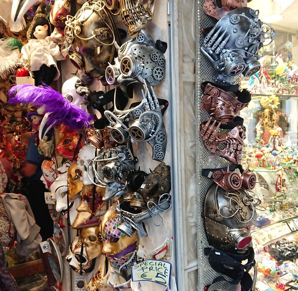 Viele unterschiedliche Masken an einer Säule in einem Geschäft. 
Schild mit "Special Price 5 €"