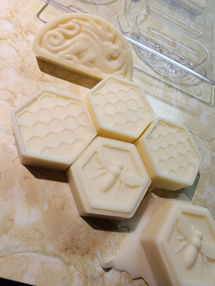 There are hexagonal soap bars depicting bees, honeycomb, and a random dragon. They are cream-colored