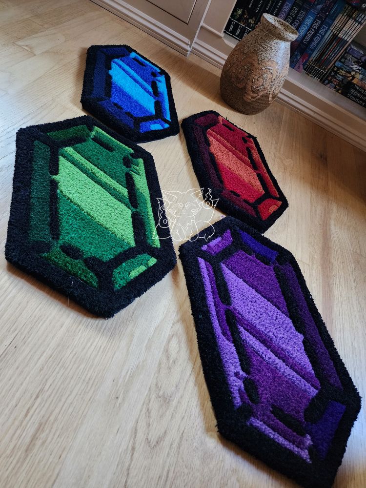 4 different colored rupees that were handmade are on the floor next to a pot, which is still intact 