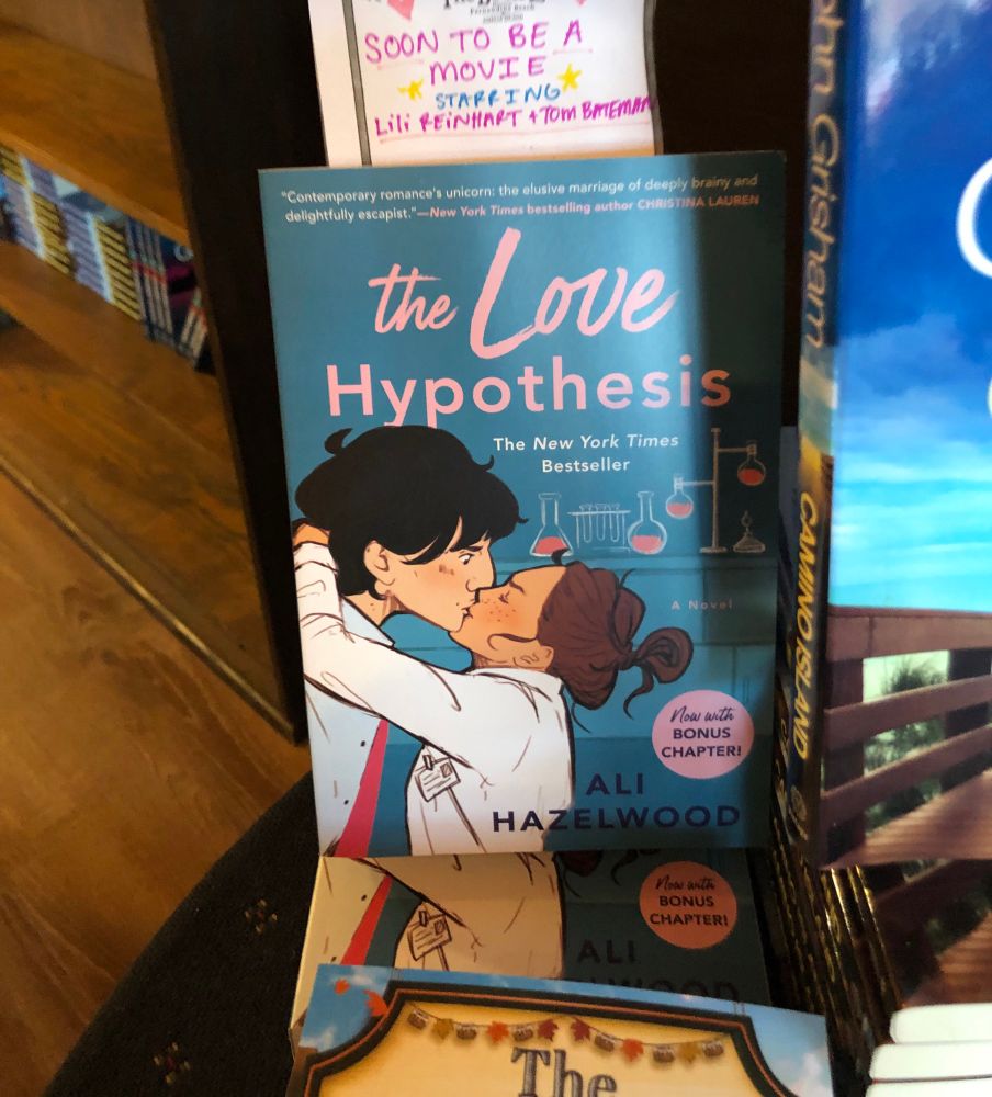Local Bookstore copy of the Love Hypothesis with a small sign decorated in hearts and stars that says “Soon to Be a Movie starring Lili Reinhart and Tom Bateman”