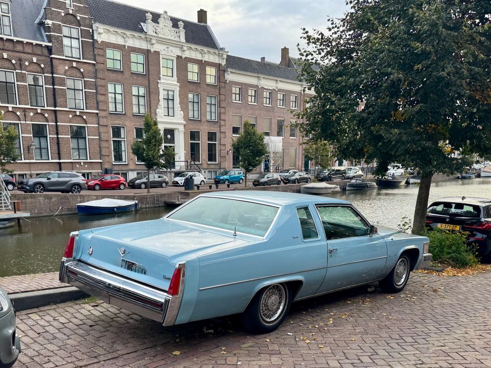 A photograph of a large baby blue vintage 1970s Cadillac coupe. 