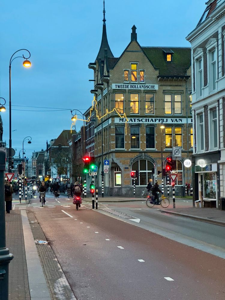 This photo is of the mixed two way bike lanes and bus lane coming from the station heading towards the south street lights are still on and the lights were one of the big brick buildings on the corner are on as well