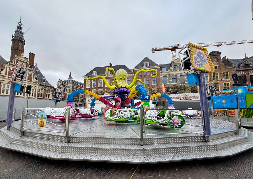 The fair ride octopus is still sleeping not yet ready to take on the crowds will be coming for the King’s birthday. It’s a gray morning with the octopus and it seats are quite colorful, yellow, purples, and greens.