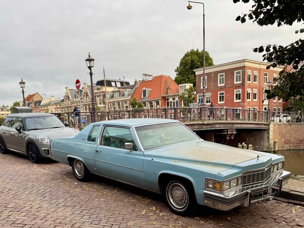A photograph of a large baby blue vintage 1970s Cadillac coupe. 
