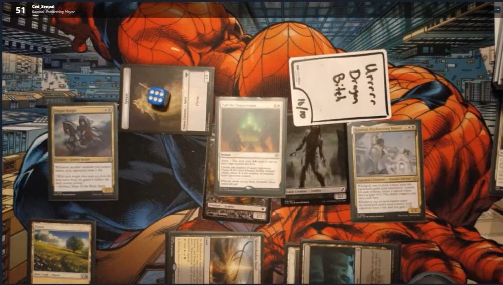 A screenshot of a SpellTable game. A playmat with Magic cards on it and an InfiniTokens dry erase token with "Urrrrr Dragon Bitch" written on it.
